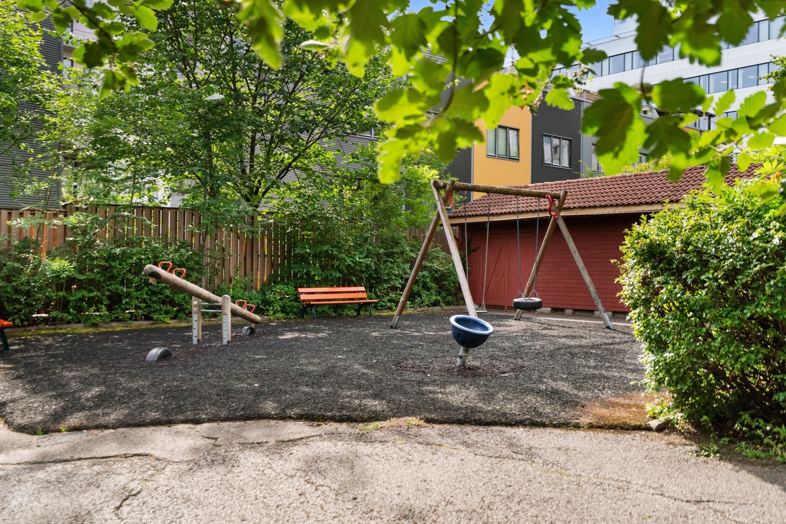 Idyllisk fellesområde med lekeplass og frodig beplantning Galleribilde