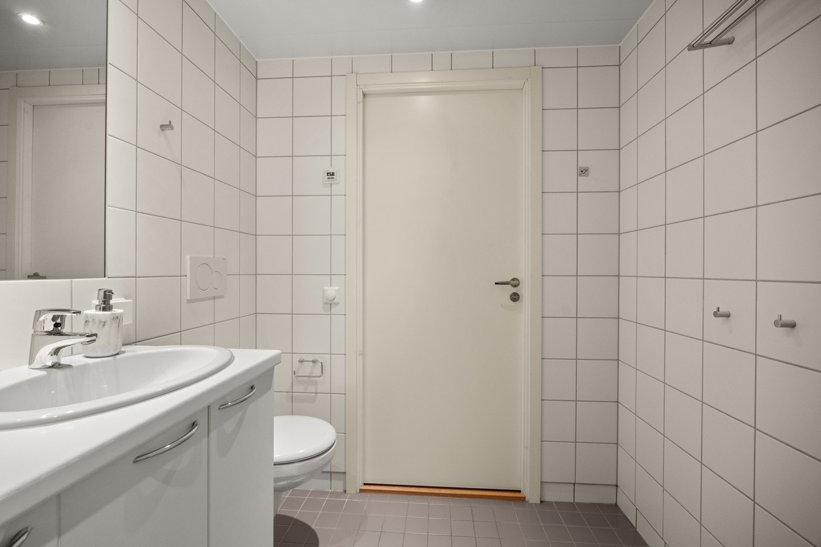 Badet har servant med underskap, innmurt speil og opplegg for vaskemaskin og tørketrommel. Galleribilde