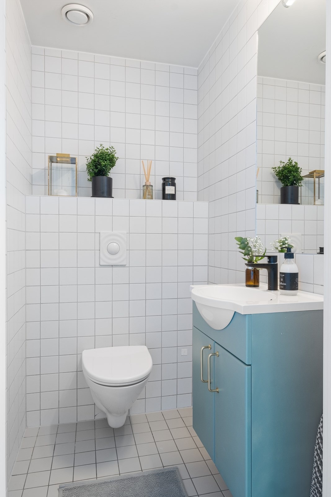 Separat toalettrom med veggmontert wc, servantinnredning med underskap, veggmontert speil og varmekabler i gulv. Galleribilde