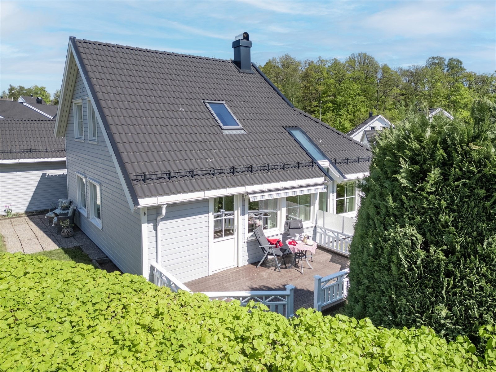 Boligen har både terrasse og platting i hagen. Tomten er fint skjermet med bøkehekk Galleribilde