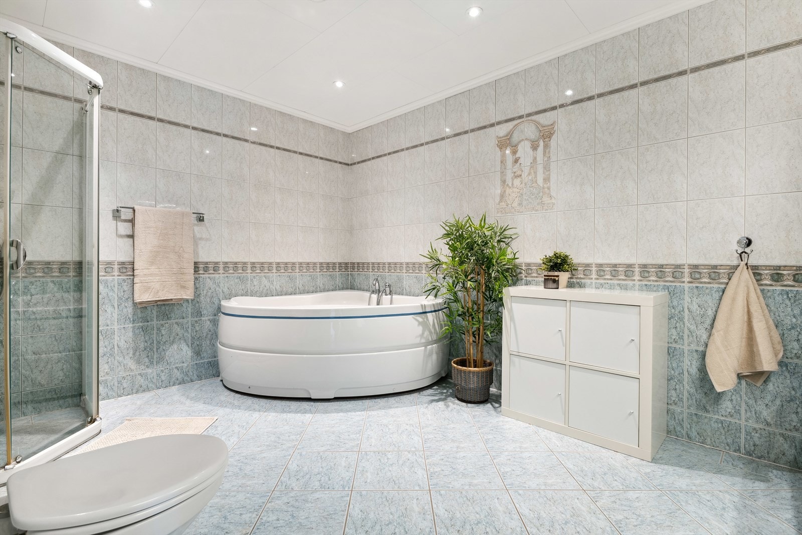 Det er videre utstyrt med vegghengt toalett, dusj, badekar og møblement med servant Galleribilde