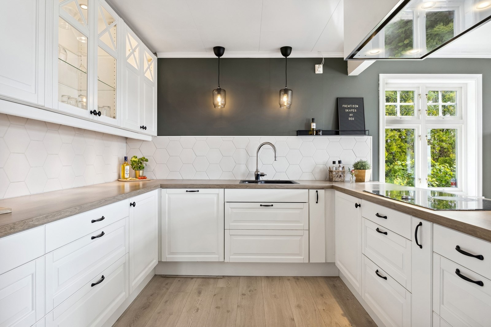 Kjøkkenet har innredning fra Epoc med hvite profilerte fronter og laminat benkeplate Galleribilde