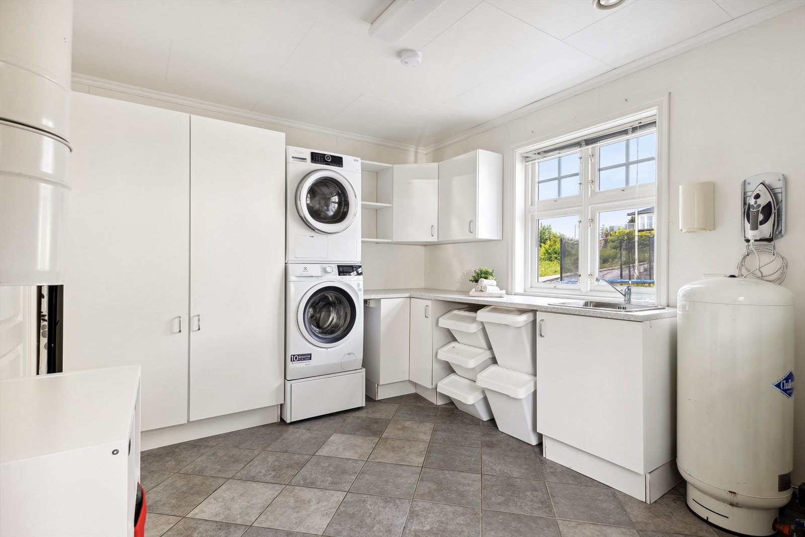 Vaskerommet har fliser på gulvet, malte flater veggene og er utstyrt med skapinnredning, vask og opplegg for vaskemaskin/tørketrommel. Galleribilde