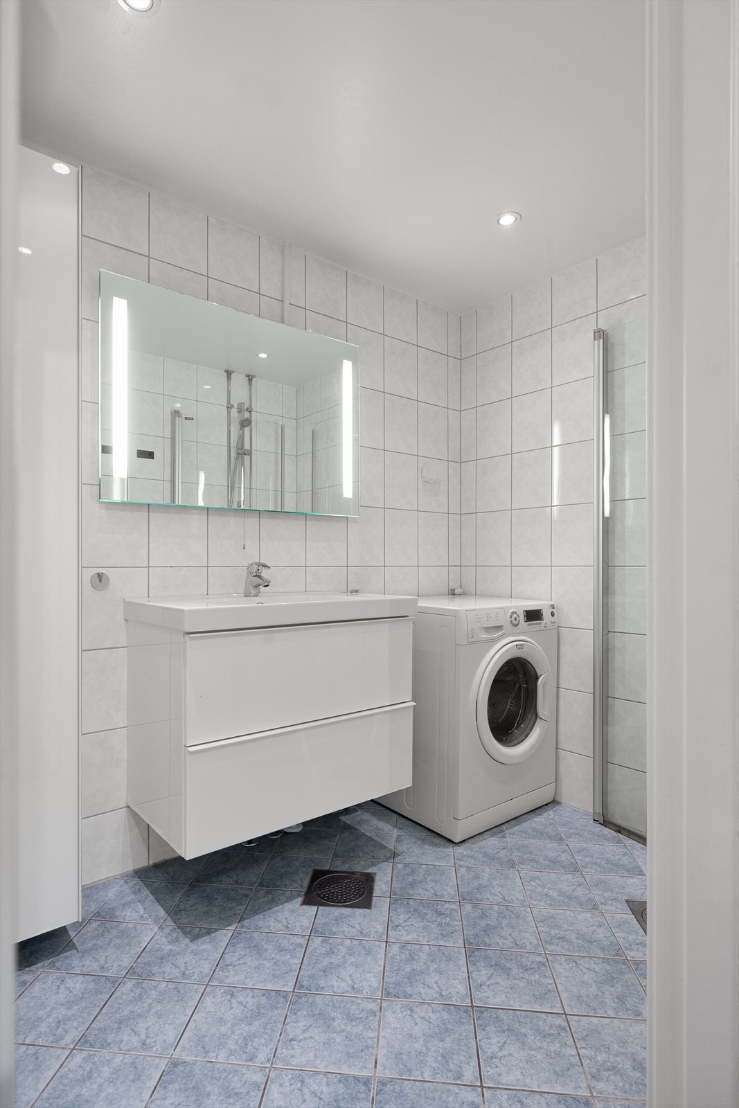 Badet har dusjhjørne med innfellbare glassdører og opplegg for vaskemaskin. Galleribilde