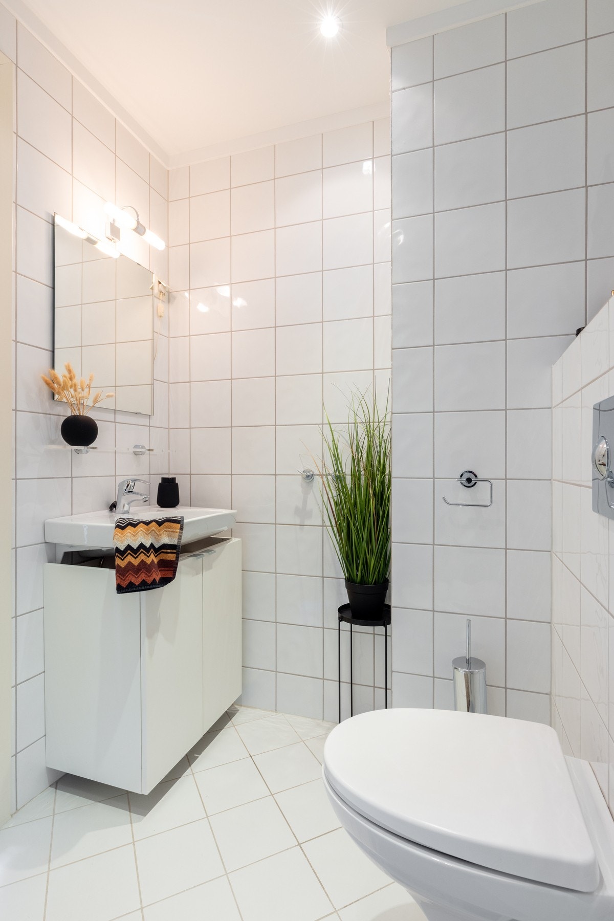 Badet er utstyrt med innredning med servant med underskap, vegghengt toalett og dusjvegger/hjørne. Galleribilde