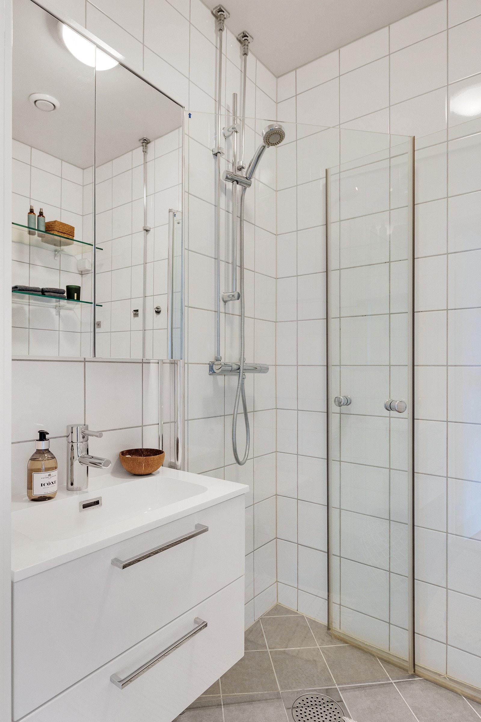Badet har veggmontert wc, heldekkende servant med servantskap, speil, dusjhjørne med innfellbare dusjdører i herdet glass og opplegg for vaskemaskin. Galleribilde