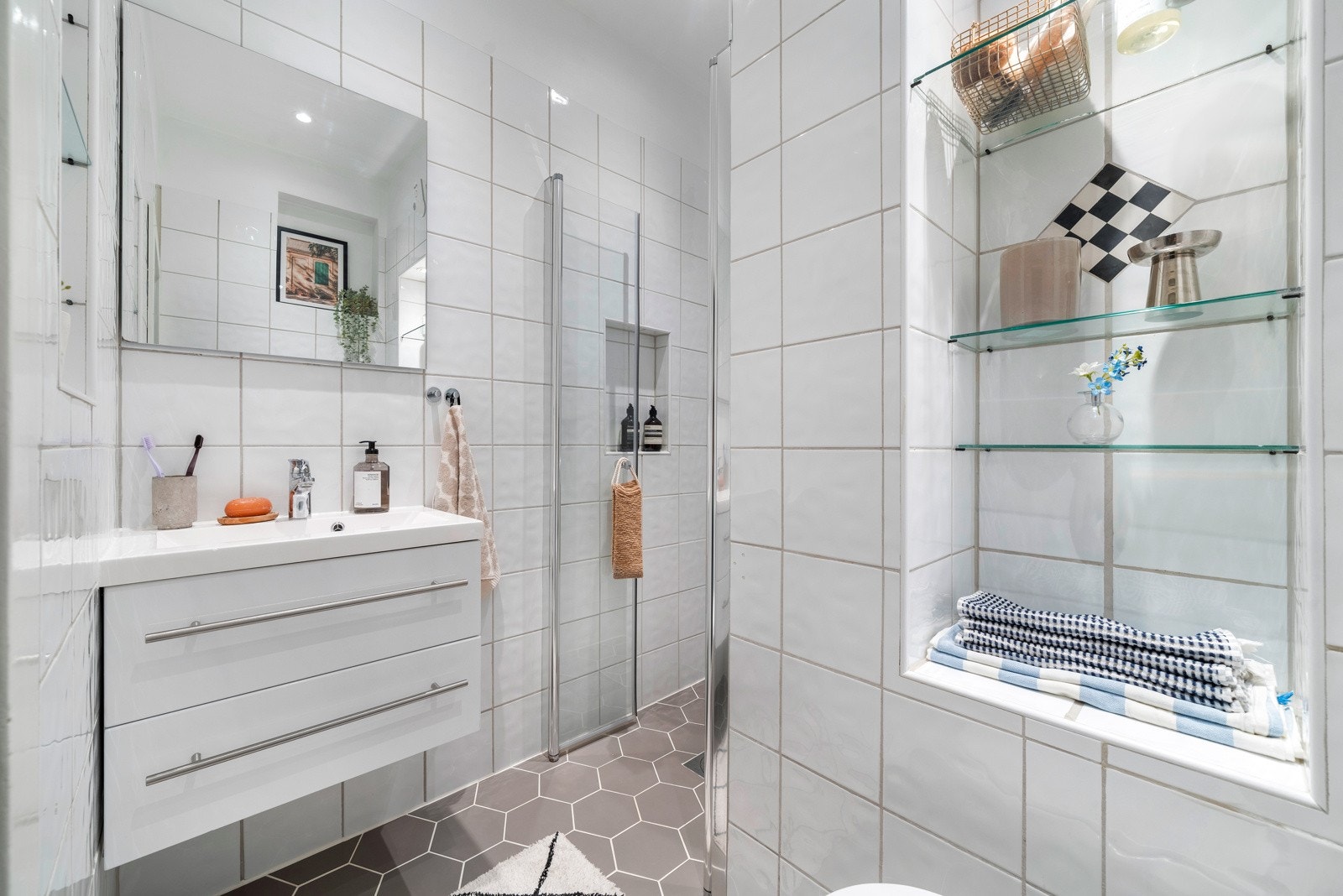 Baderommet består av flislagte gulv med behagelig gulvvarme og flislagte vegger, som skaper et moderne og lettstelt preg. Galleribilde