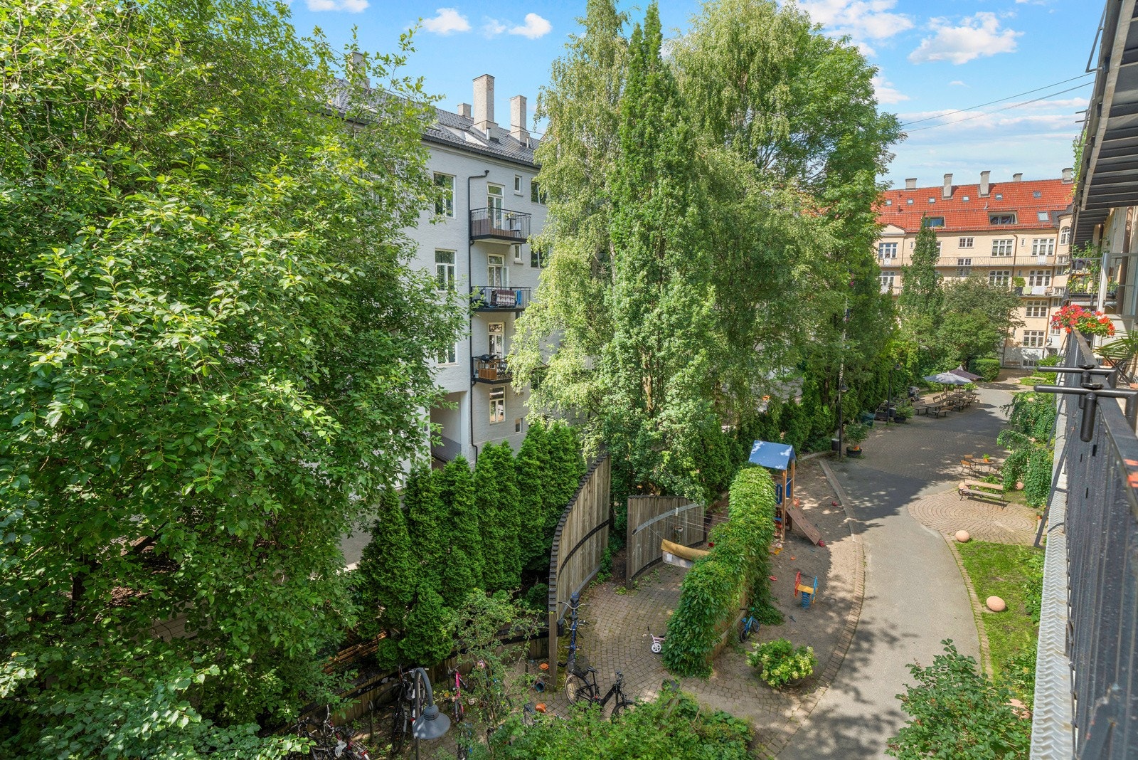 Rolig bakgård med grønne omgivelser, sittegrupper og lekeapparater. Dette gjør det både hyggelig og innbydende for avslapning og sosiale sammenkomster. Galleribilde