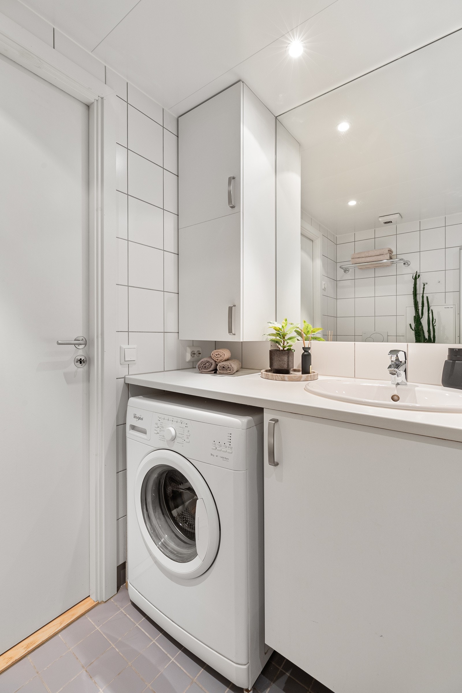 Badet har opplegg for vaskemaskin og tørketrommel under baderomsbenk Galleribilde