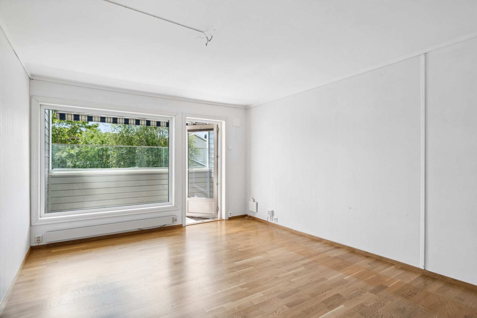 Leiligheten har en lys og romslig stue med parkett på gulvet. Galleribilde