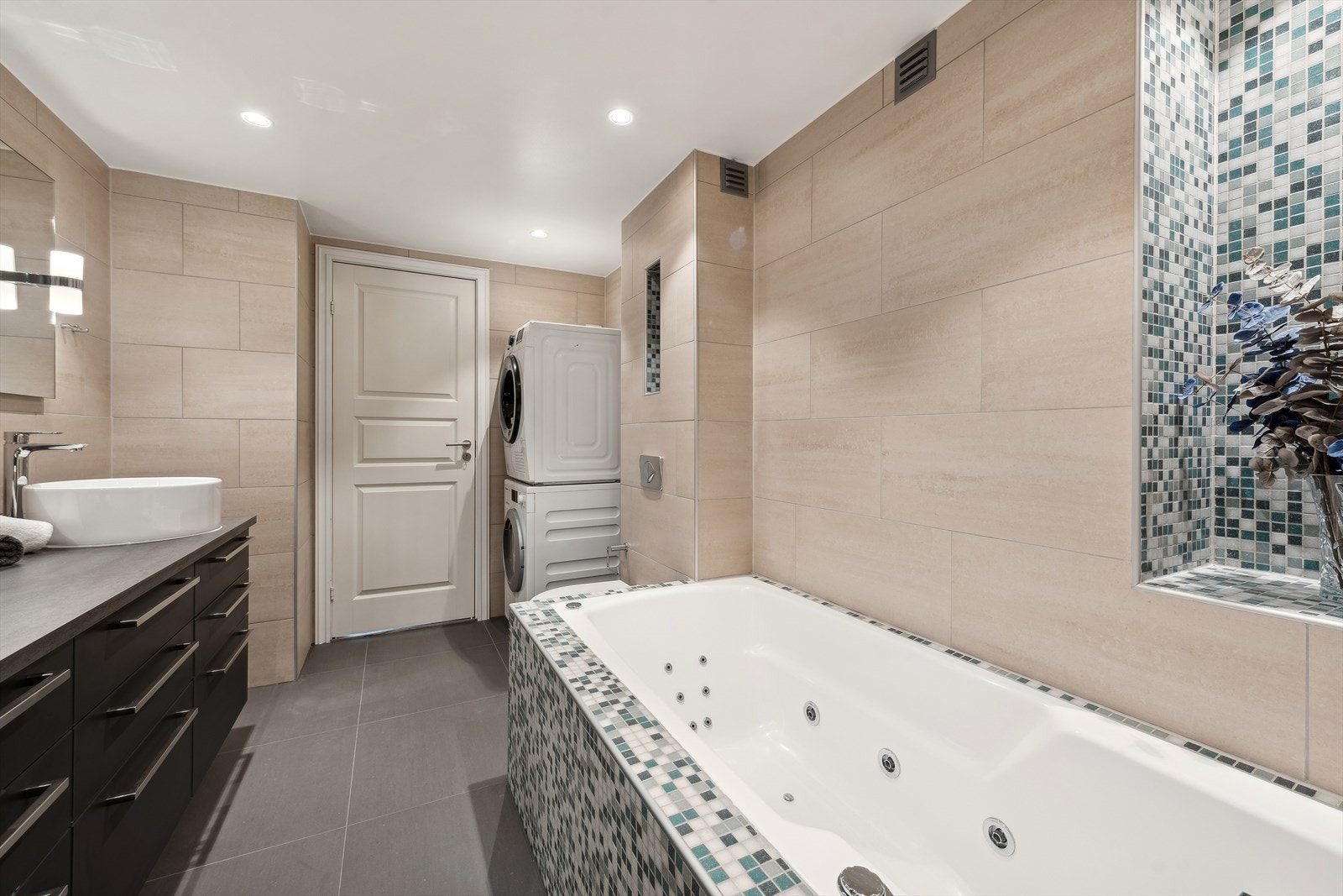 Badet er innredet med badekar, opplegg for vaskemaskin og innredning med dobbel servant. Galleribilde