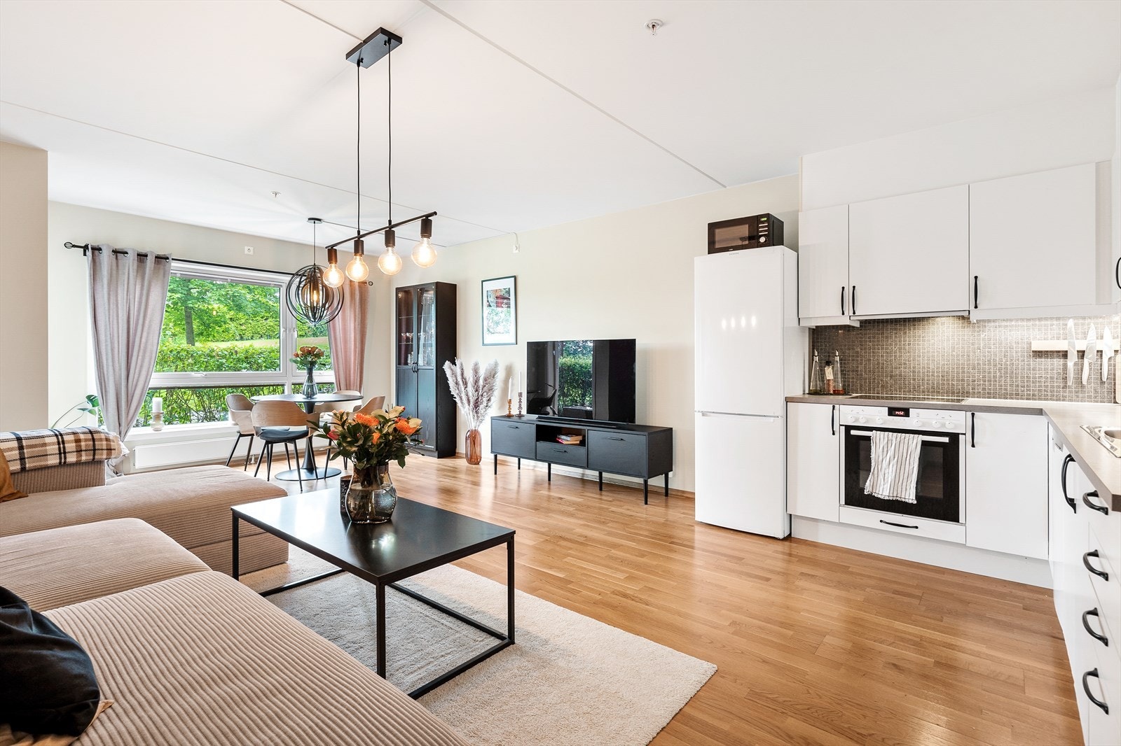 Kjøkkenet har tidløs innredning med integrerte hvitevarer som stekeovn, Galleribilde