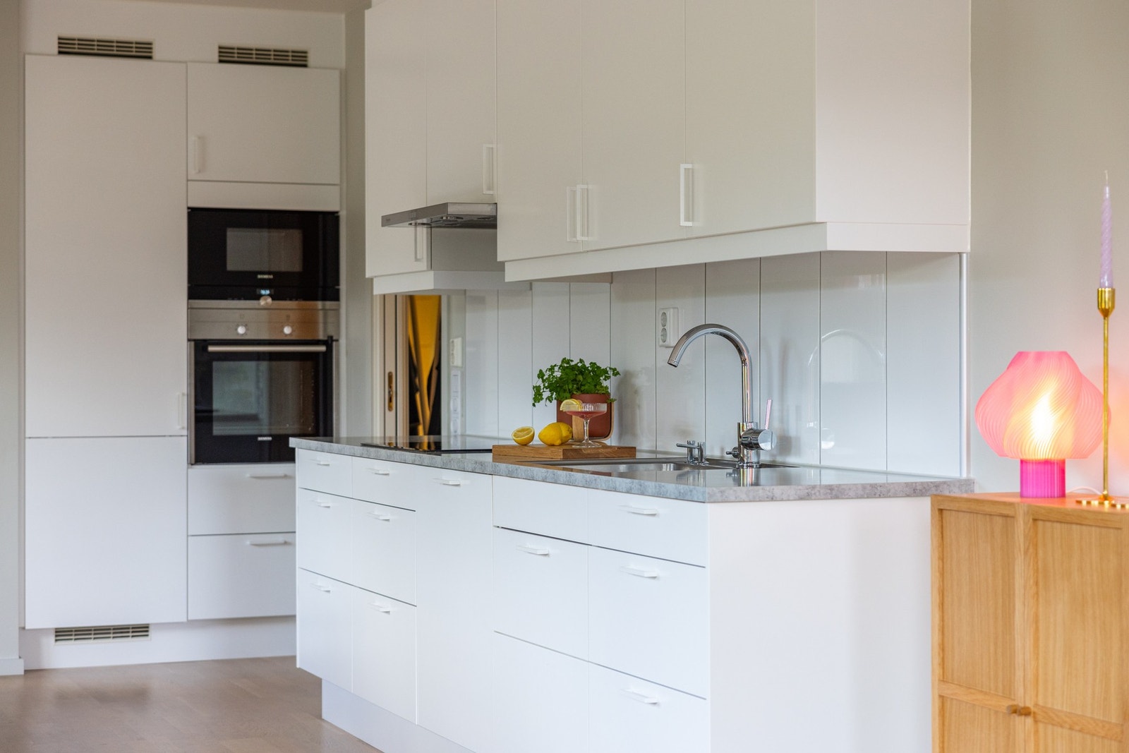 Marbodal-kjøkkenet består av lyse, slette fronter med benkeplate i laminat og nedfelt oppvaskkum med ett-greps armatur. Benkeskapsbelysning og stikkontakter under overskap. Galleribilde