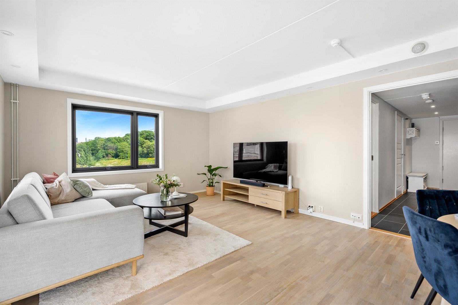 Lys og romslig stue med store vindusflater som slipper inn rikelig med lys og luft. Beliggenheten på hjørnet sørger for lysinnslipp fra to retninger, her er leiligheten fylt med dagslys mesteparten av dagen. Galleribilde