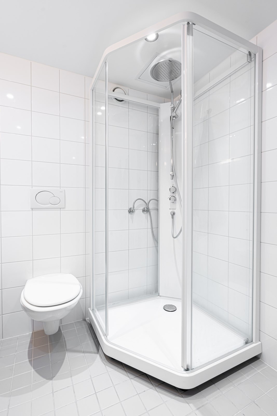 Videre består innredningen av dusjkabinett og vegghengt toalett med innebygget sisterne. Opplegg for vaskemaskin og mekanisk avtrekksventil på vegg. Galleribilde