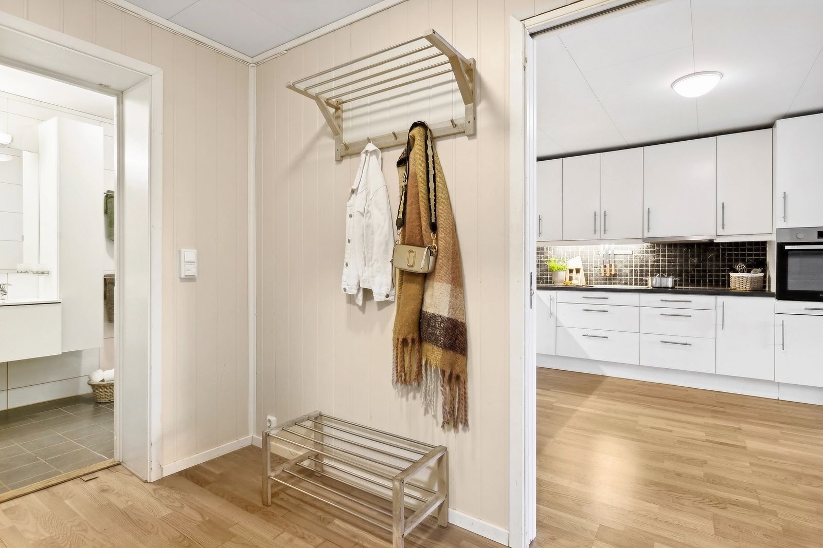 Fin entre som er det første man møter når man går inn i leiligheten. Her er det oppheng til klær. Galleribilde