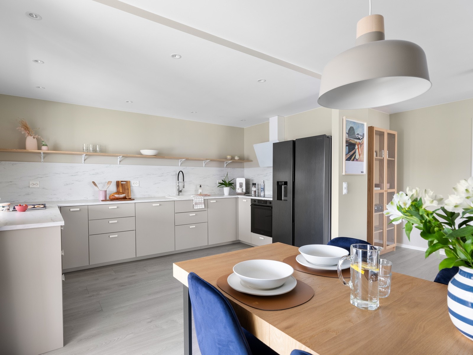 Leiligheten har et tidløst og moderne IKEA-kjøkken fra 2023 med grå, slette fronter, oppført i en funksjonell U-form med god benk- og skapplass. Galleribilde