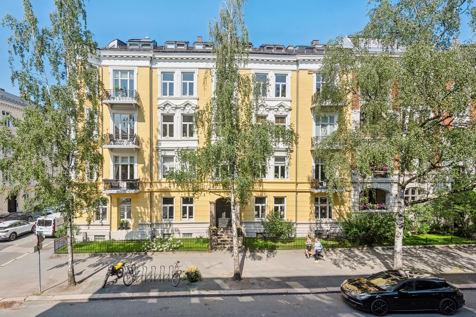Representativ bygård med forhage med plen og gjerde mot fortau. Galleribilde