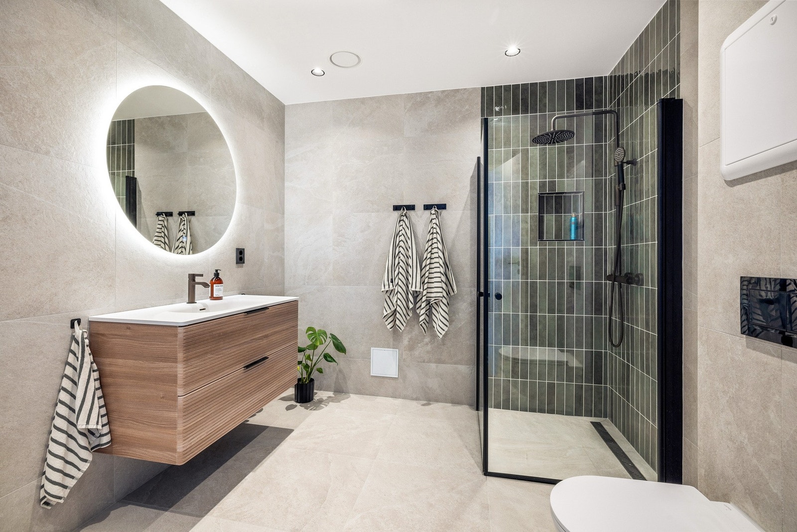 Store fliser i pen grå/beige tone mot lekker dekorflis i dusjsone Galleribilde