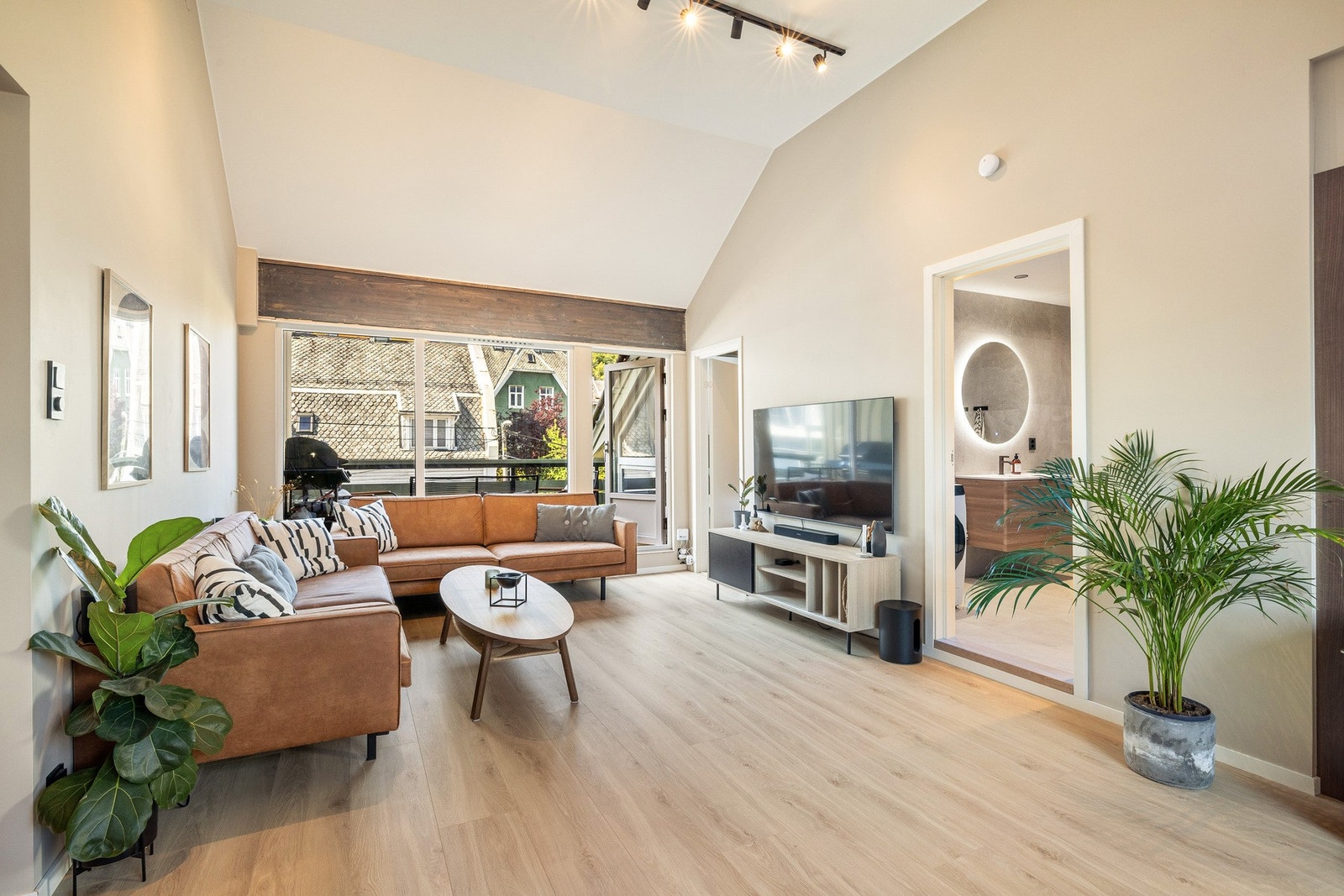 Lyse, slette overflater og gulv med enstavs laminat i pen eikefarge Galleribilde