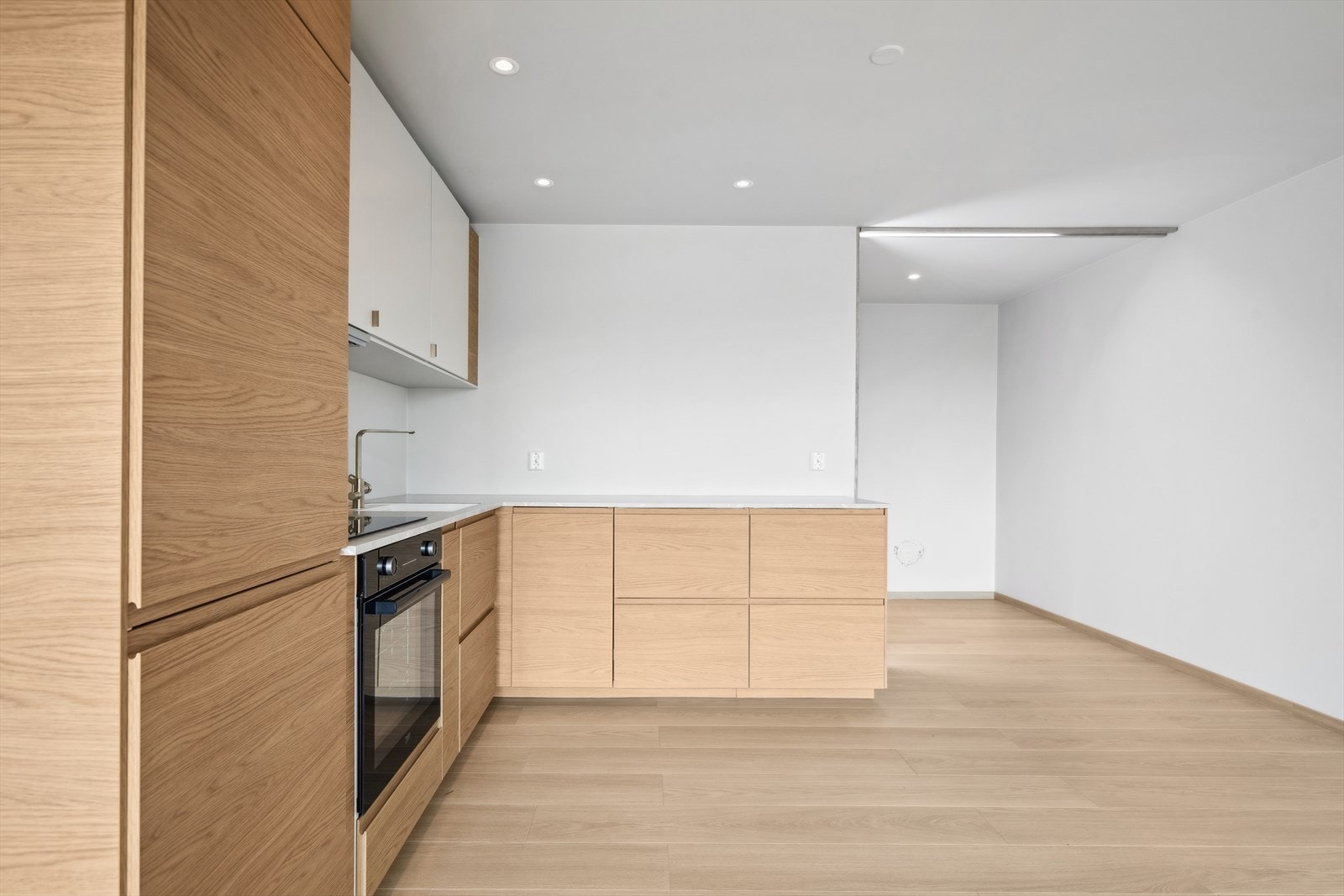 Kjøkkenet er godt tilpasset leiligheten og utnytter arealet effektivt Galleribilde