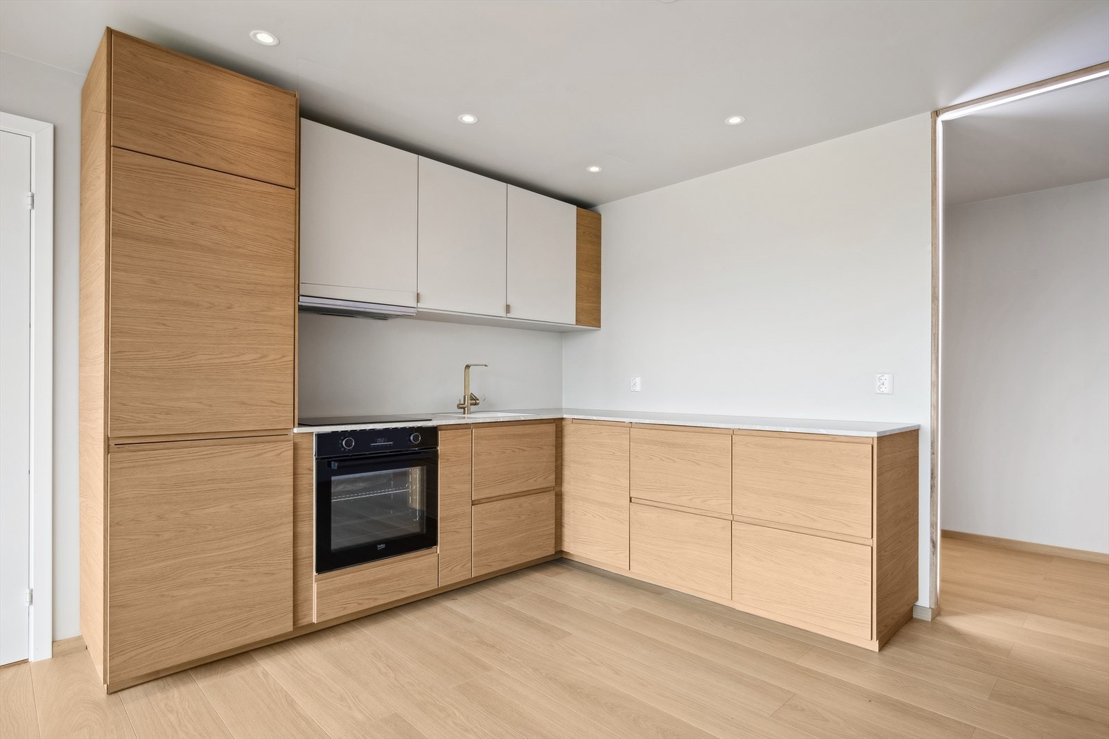 Lekkert kjøkken med mye oppbevaringsplass og integrerte hvitevarer Galleribilde