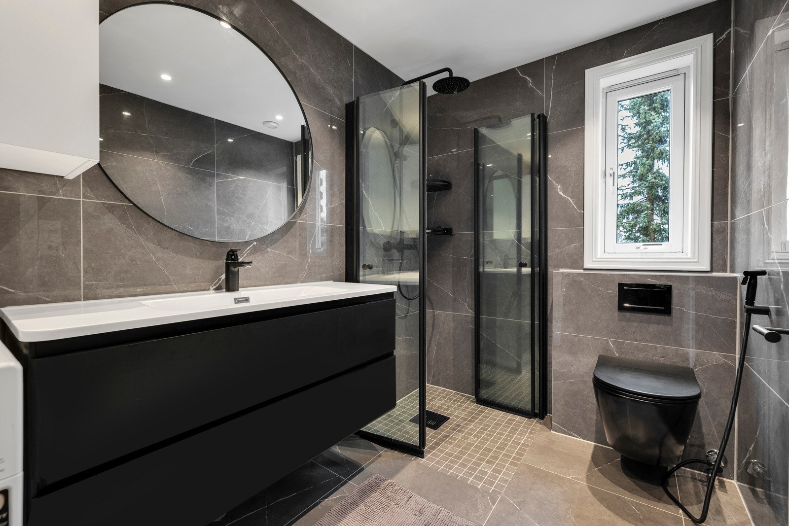 Lekkert bad fra 2023. Badet har dusjhjørne med nedfliset dusjsone og foldedører i glass Galleribilde