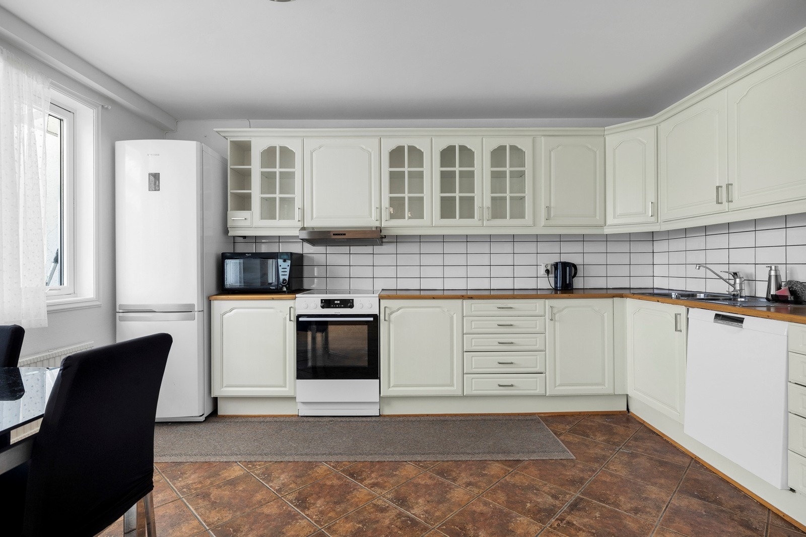 Kjøkkenet har godt med skap- og benkeplass, og har avsatt plass til frittstående hvitevarer Galleribilde