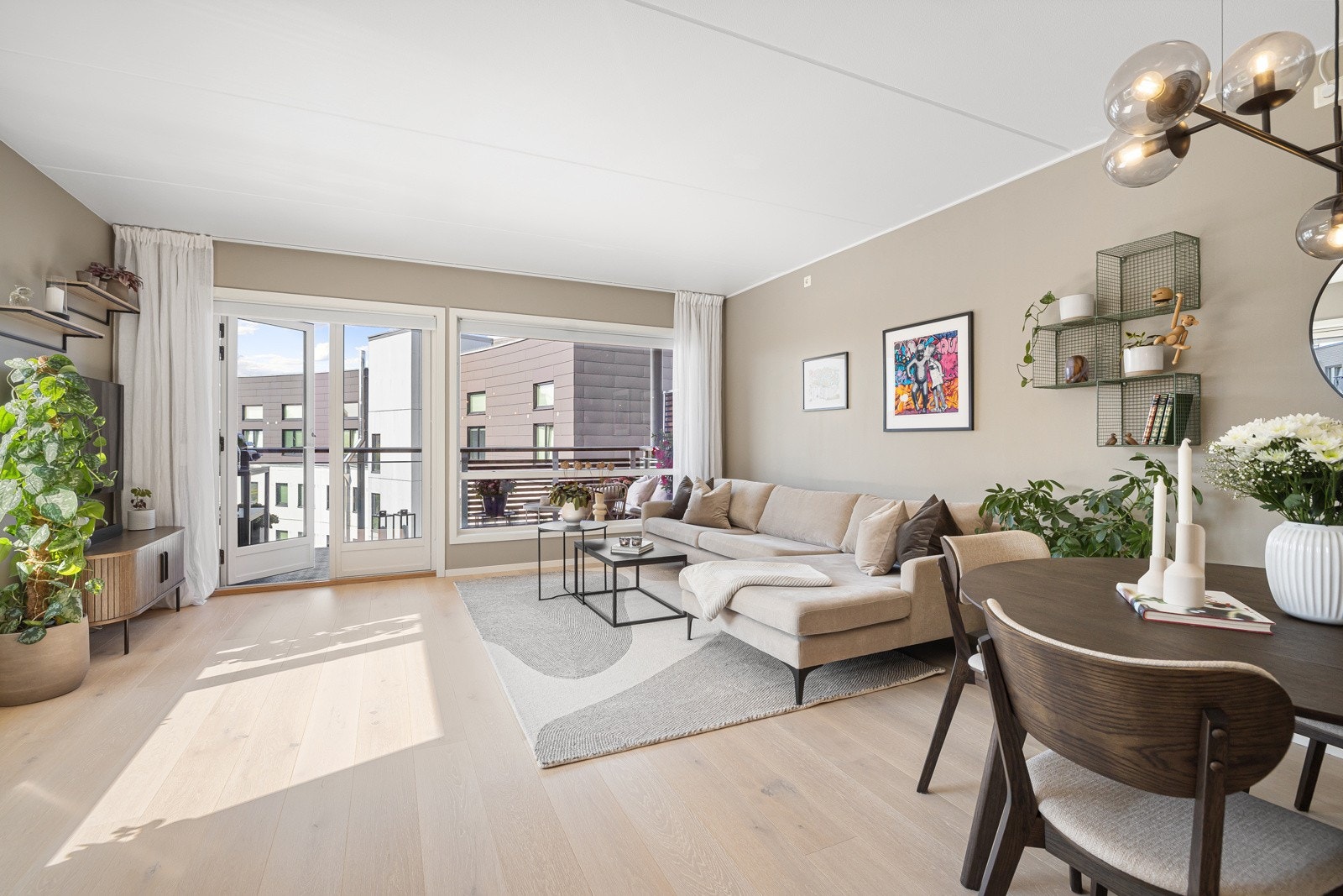 Åpen løsning mellom stue og kjøkken med god plass til sofagruppe, spisebord og annet ønskelig møblement Galleribilde