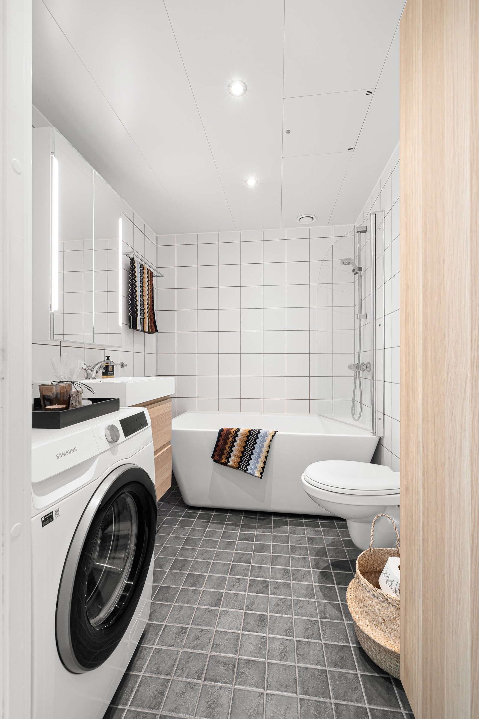 Badet er utstyrt med et badekar med blandebatteri og dusjslange fra Oras, et veggmontert toalett og opplegg for vaskemaskin Galleribilde