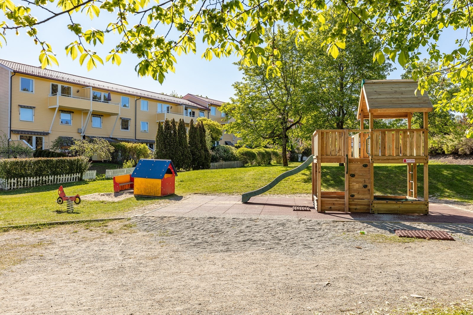 Leiligheten er en del av Skovbakken Borettslag med velholdte grøntarealer og lekeplass for de minste (Bildet er tatt fra borettslagets hjemmside). Galleribilde