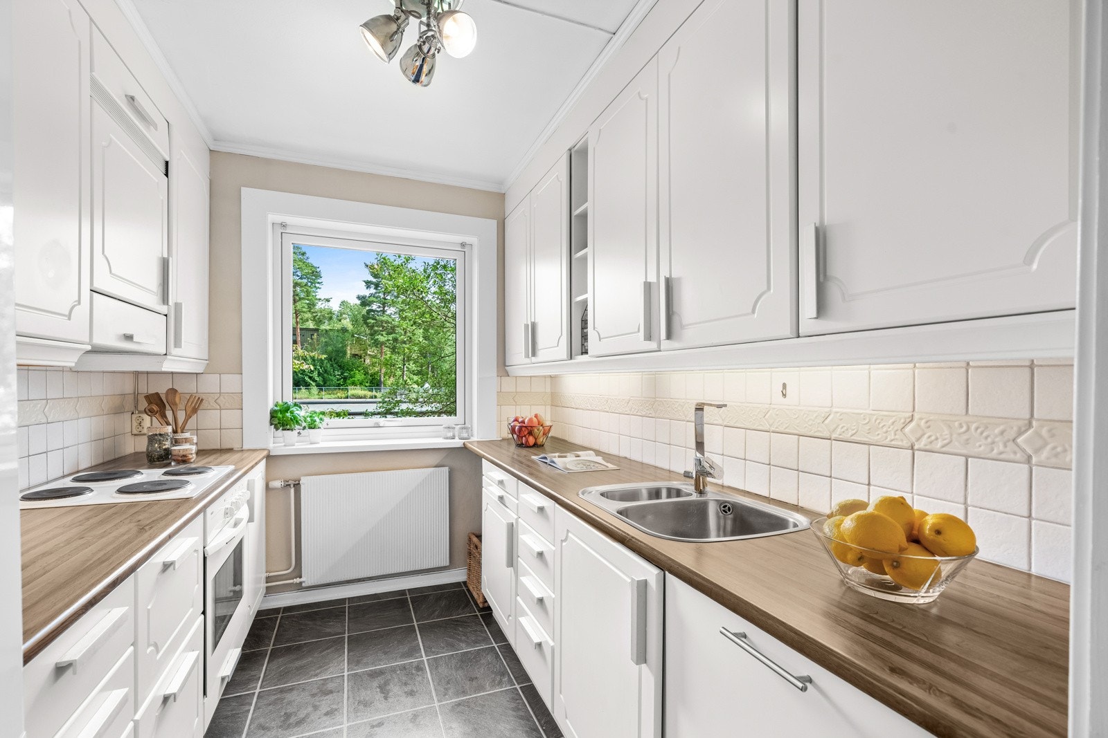 Separat og romslig kjøkken med kjøkkeninnredning fra to sider. Galleribilde