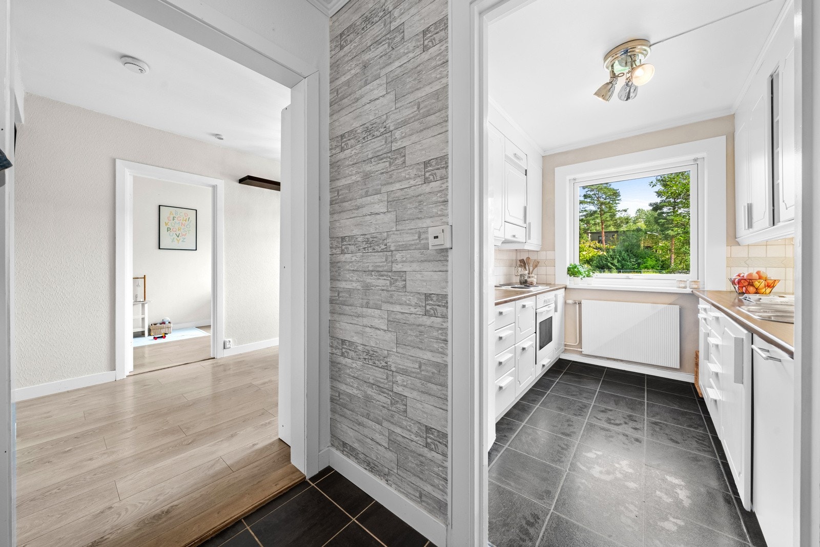 Kjøkkeninnredningen byr på godt med skap- og benkeplass fra to sider som gjør matlaging og oppbevaring smidig" Galleribilde