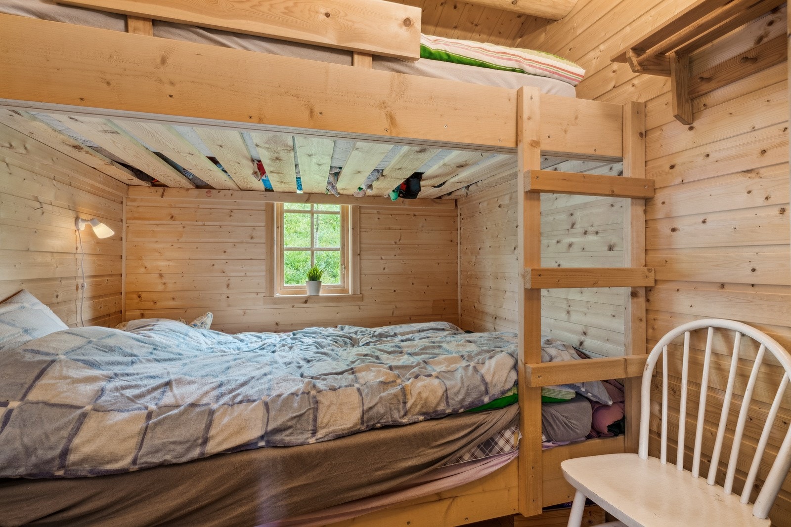 Det er et soverom i hytta, innredet med køyeseng. Galleribilde