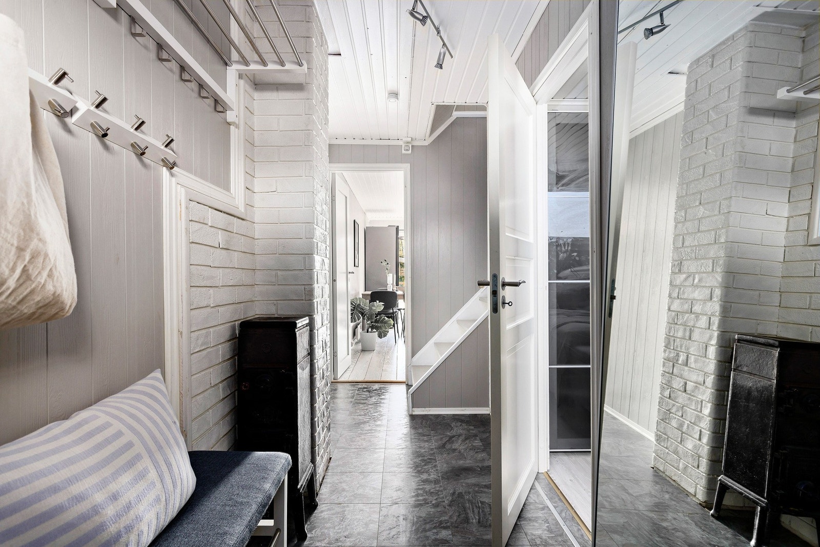 Entréen er lys og pen med laminat på gulv og malt panel. Her er det plass til knaggrekke, speil og oppbevaringsmøblement. Galleribilde