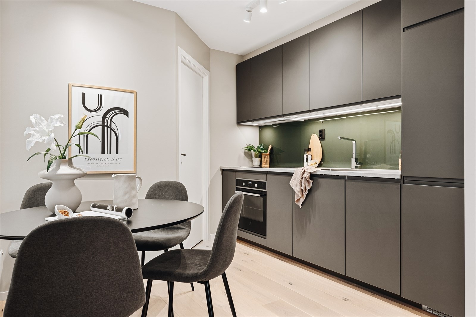 Kjøkkenet er velutstyrt og fremstår som et møbel i seg selv med slette fronter i grå utførelse. Galleribilde