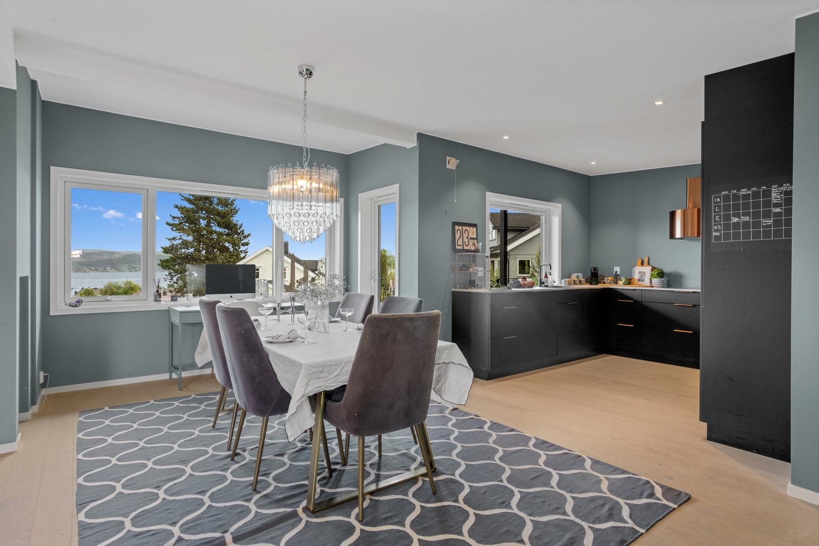 Det åpne kjøkkenet har parkett på gulvet, downlightsbelysning og store vinduer med utsikt over fjorden Galleribilde