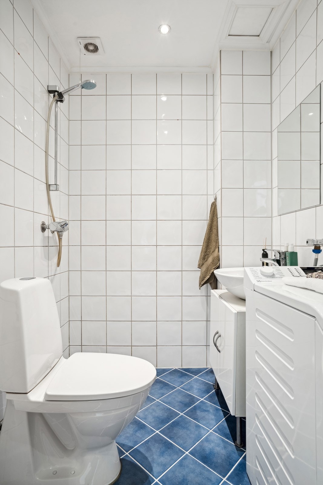 Baderommet har flis på gulv- og vegger, malt himling med spotter i tak. Galleribilde