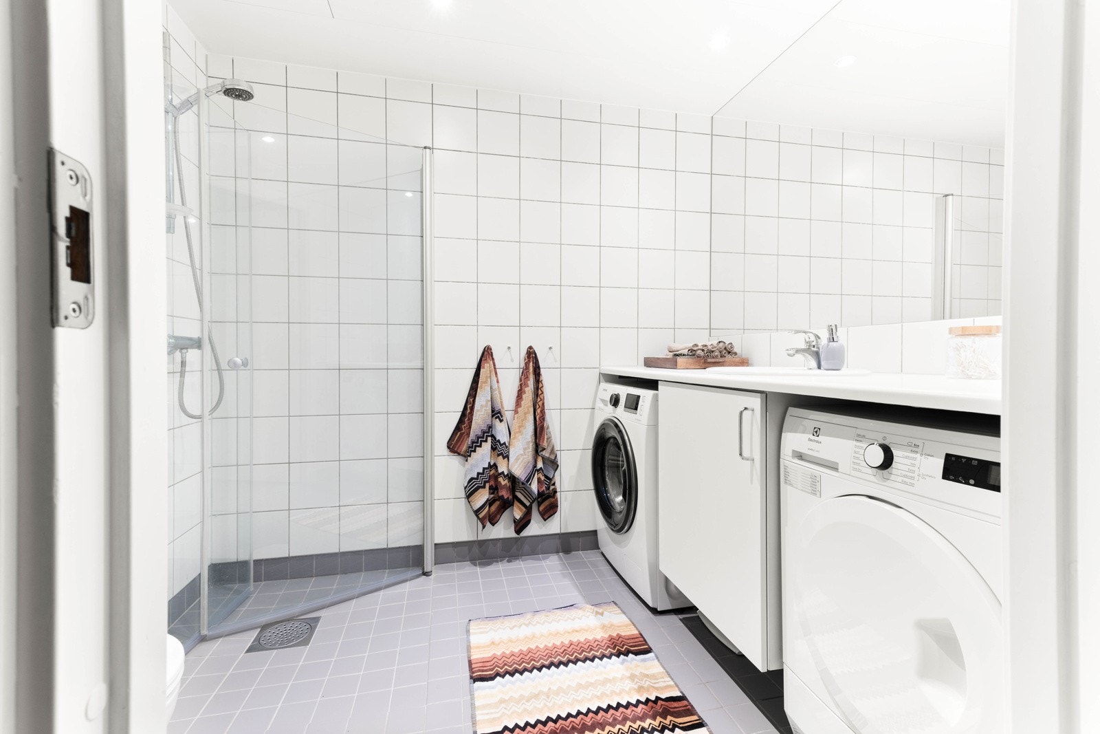 Flislagt gulv med varmekabler i gulv og opplegg for vaskemaskin og tørketrommel. Galleribilde