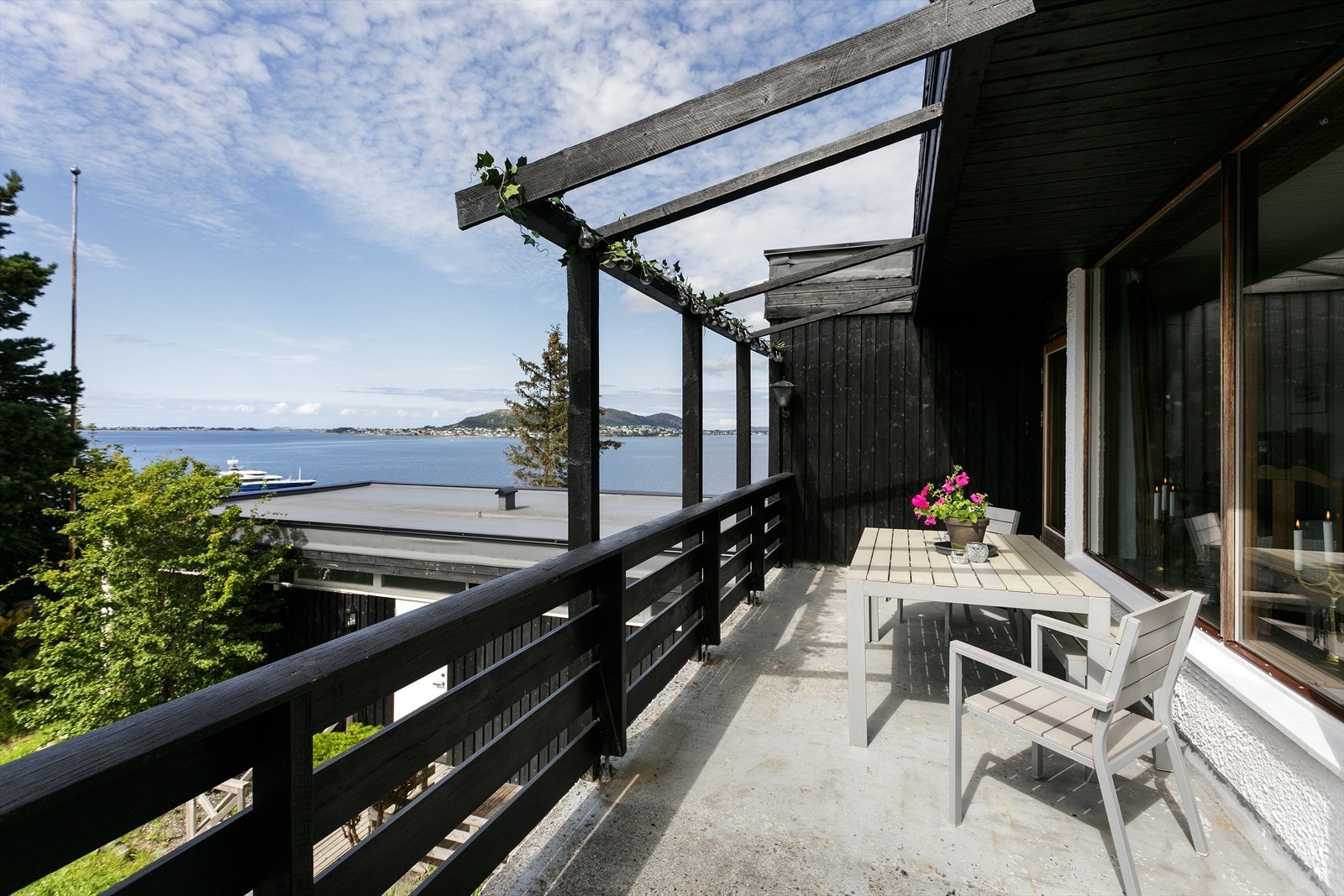 Terrasse på venstresiden av huset med utsikt mot Valderøya og Giske Galleribilde