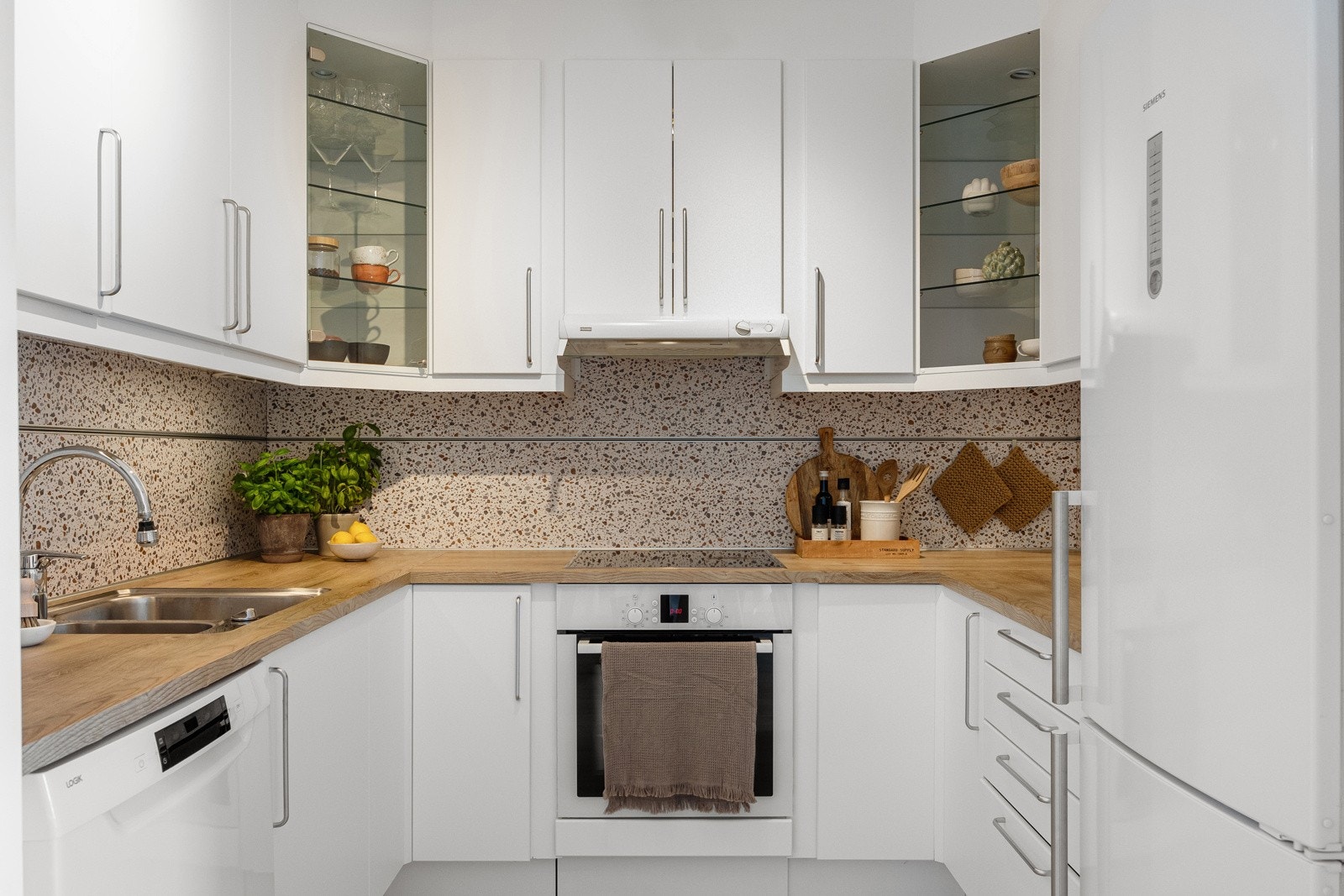 Du har plater som backsplash mellom benkeplate og overskap. Kjøkkenet har gode oppbevaringsmuligheter. Galleribilde