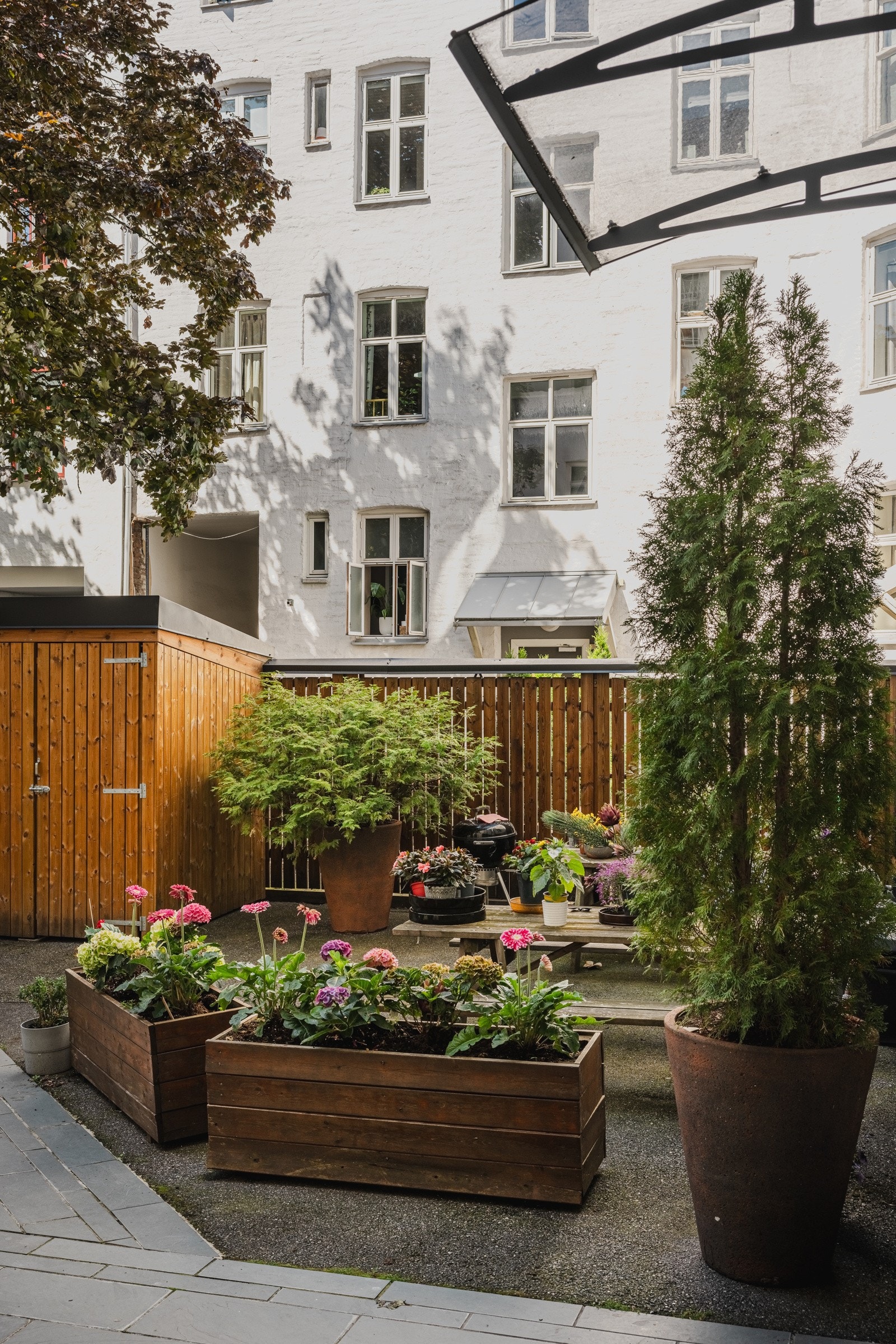 Lekker og velholdt bakgård med beplantning, som gir et godt førsteinntrykk av gården Galleribilde