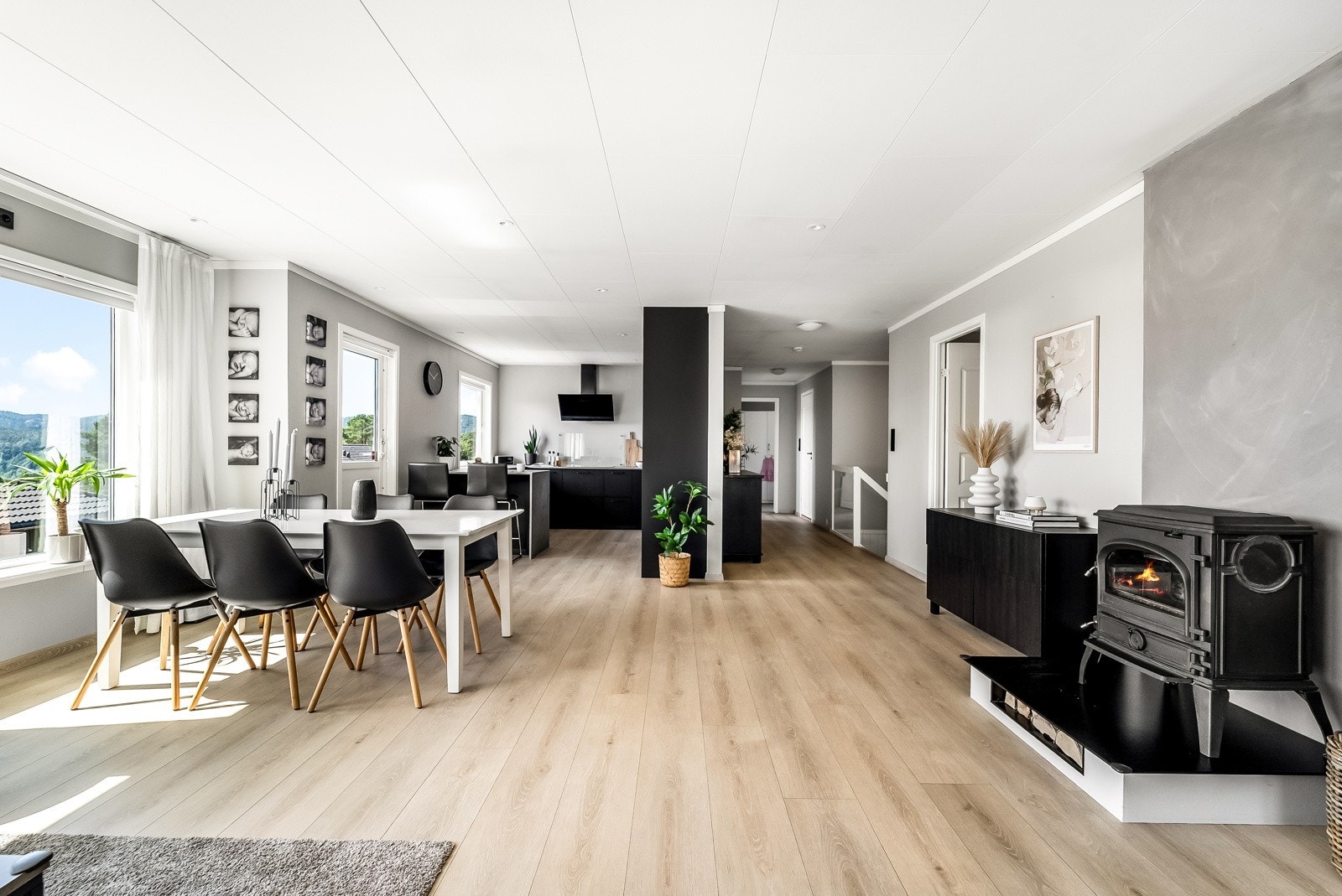 Romslig og moderne stue med vedovn og åpen kjøkkenløsning. Galleribilde