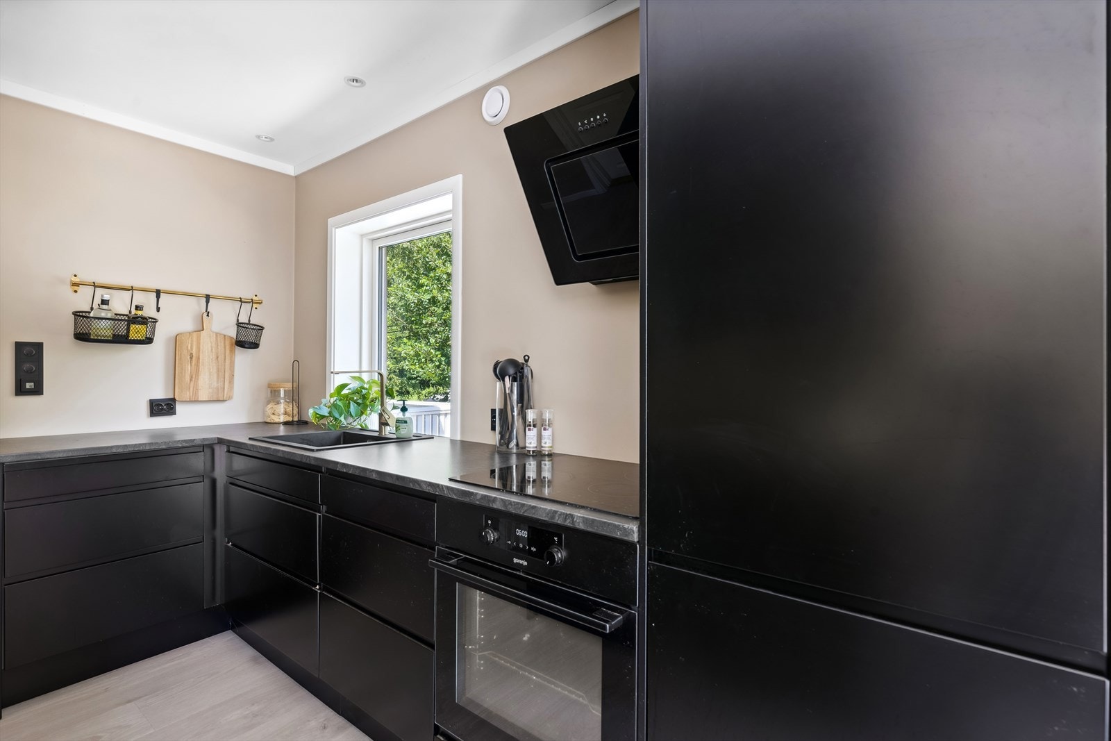 Innredningen har glatte fronter, laminat benkeplate med nedfelt kum i rustfritt stål, belysning under overskap og ventilator. Galleribilde