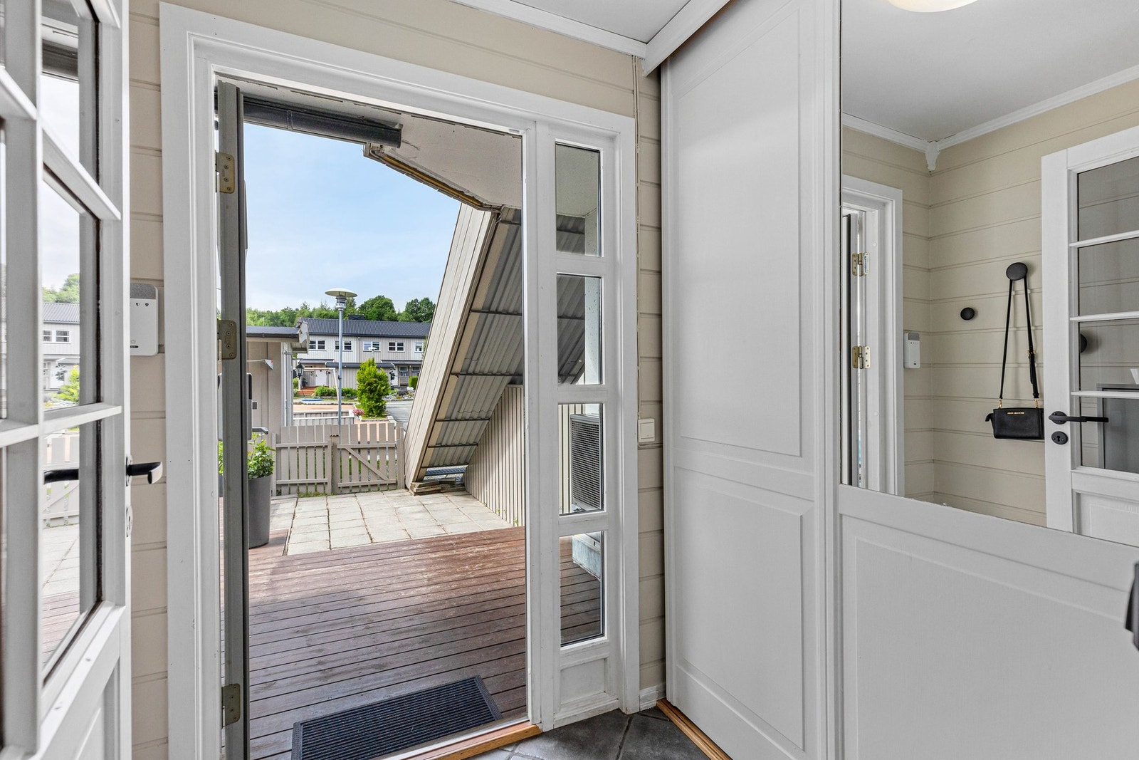 Innbydende, flislagt entré med god oppbevaringsplass i skyvedørsgarderobe. Galleribilde