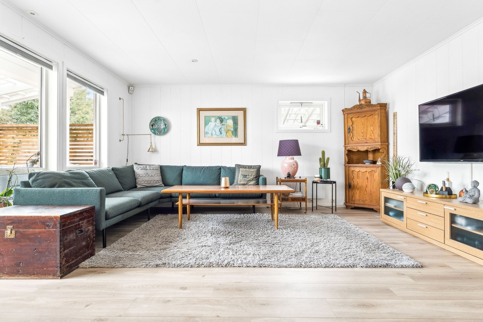 Stor og luftig stue som rommer en stor sofa og tv møblement. Galleribilde