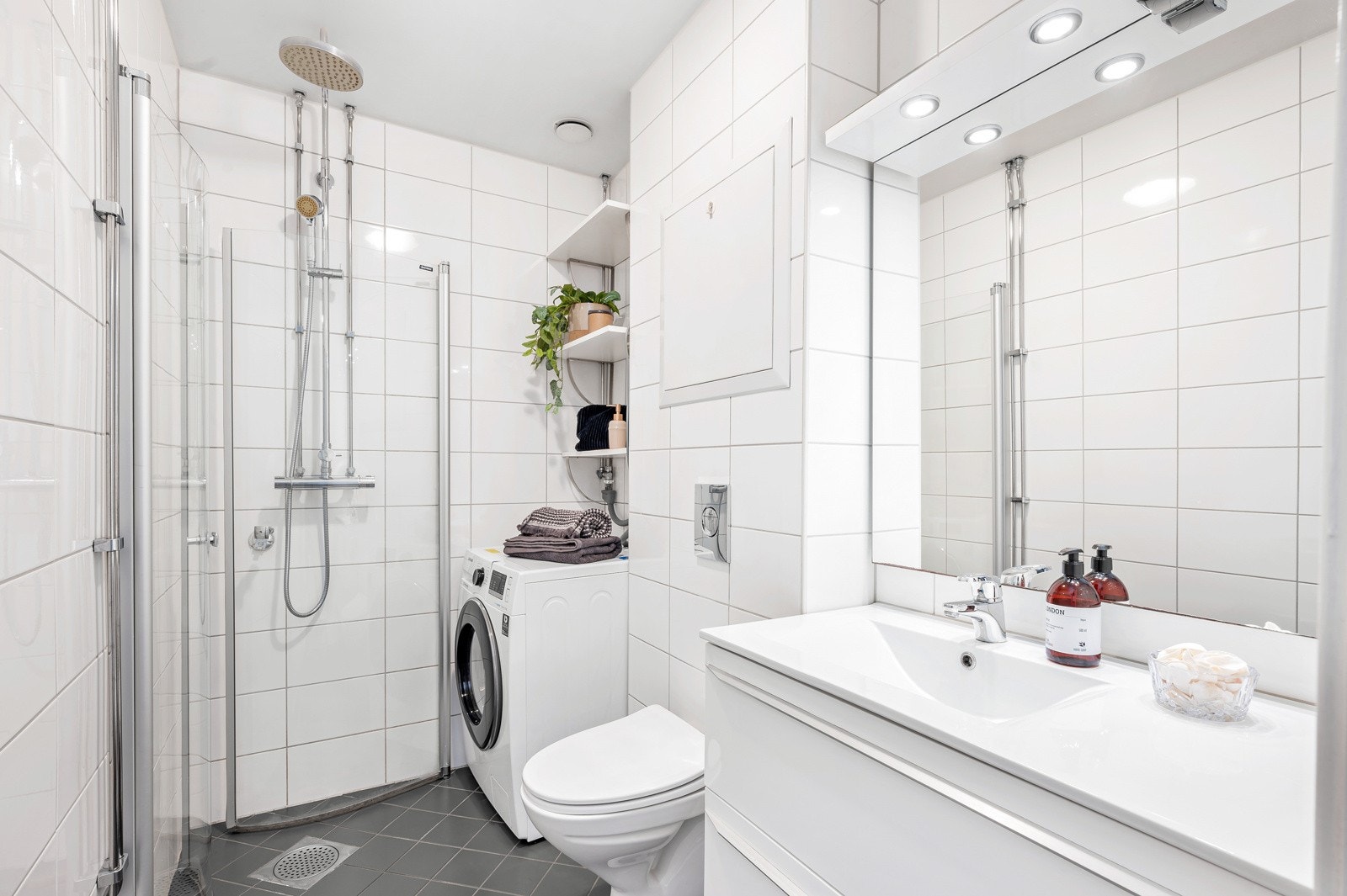 Badet har pent flislagte gulv og vegger, gulvvarme og opplegg for vaskemaskin. Galleribilde