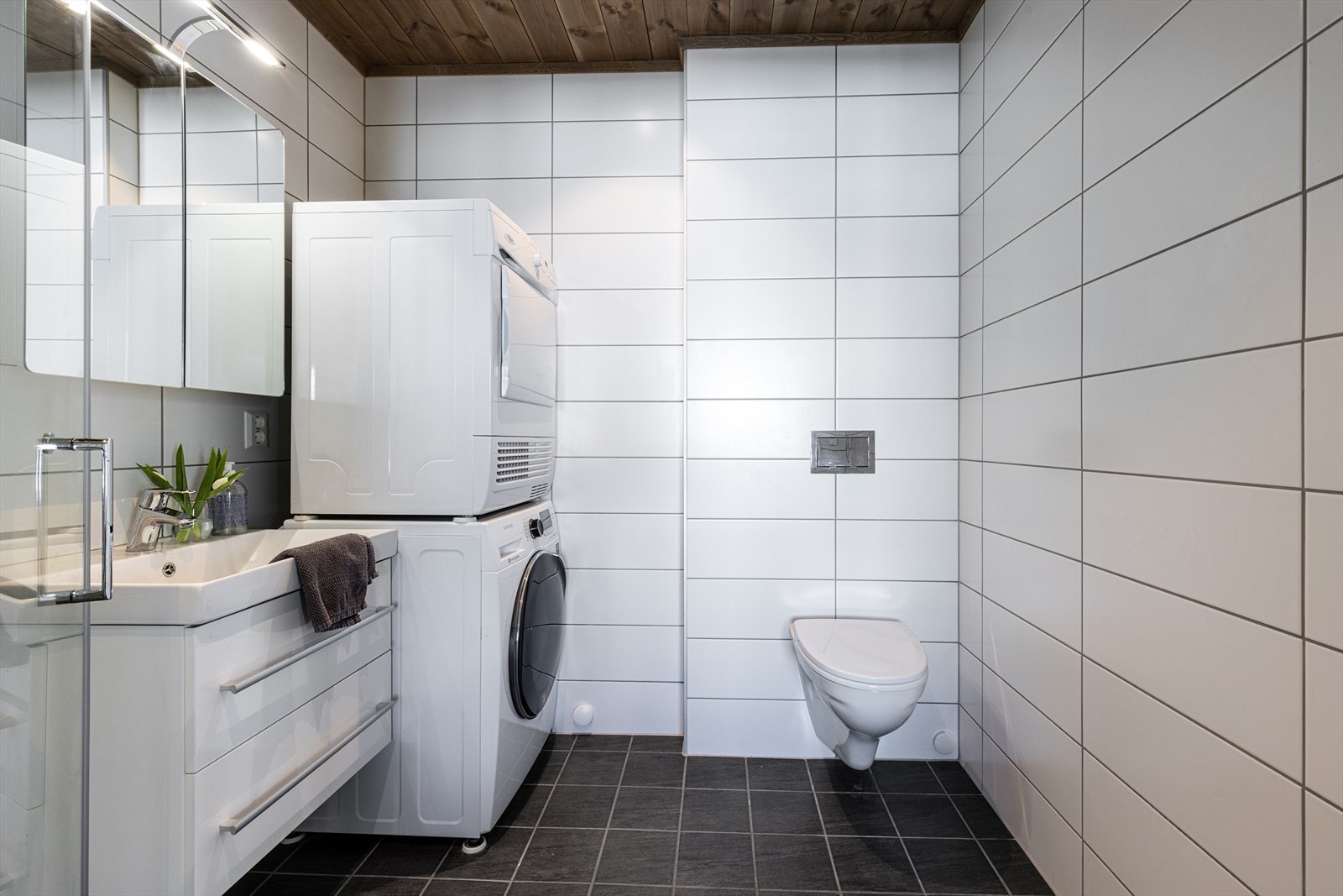 Baderom tilknyttet hovedsoverommet med opplegg for vaskemaskin og tørketrommel. Galleribilde