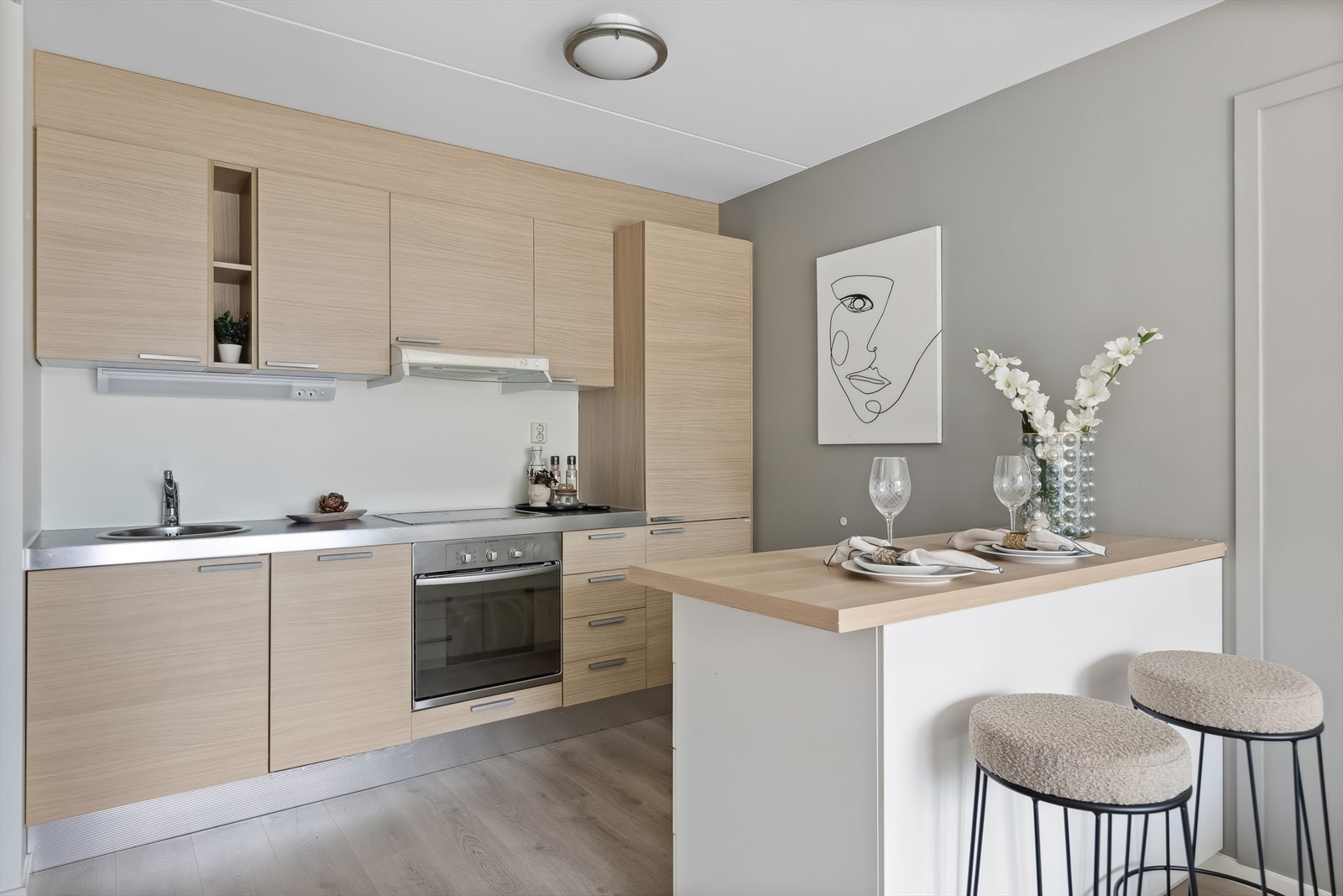 Flott kjøkkeninnredning fra Aran World . Kjøkkeninnredning med glatte fronter. Belysning under overskap. Laminat benkeplate med nedfelt kum i rustfritt stål. Galleribilde