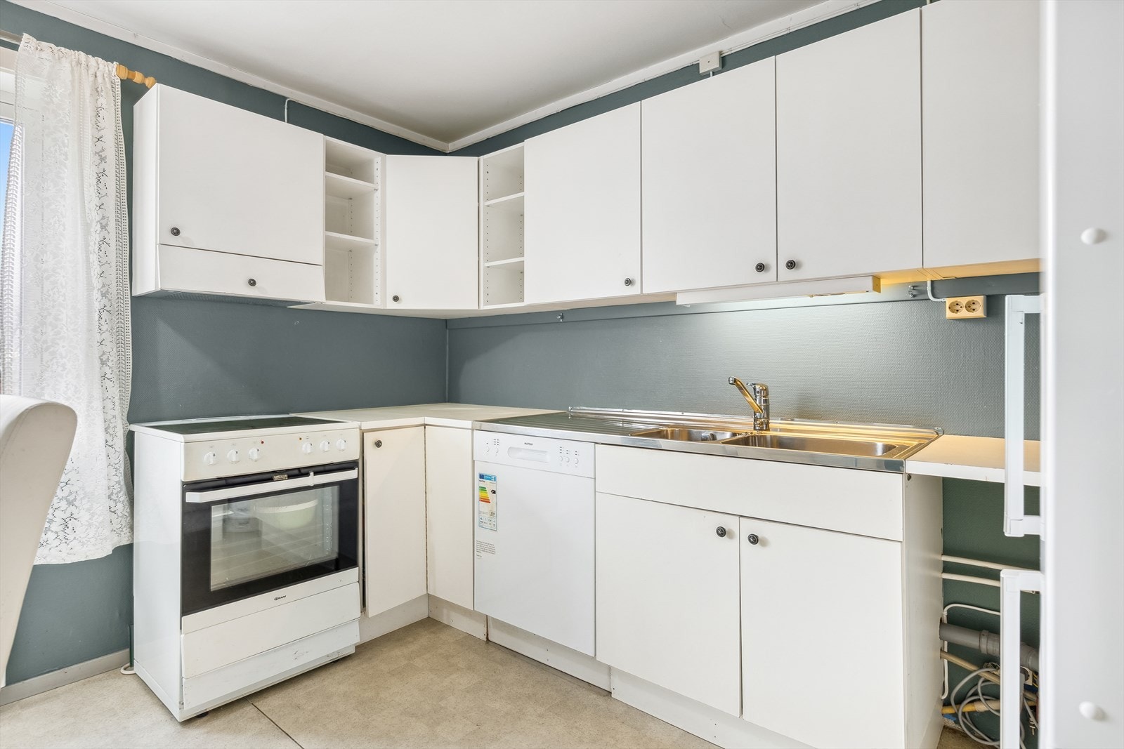 Kjøkkenet har innredning med glatte fronter, laminat benkeplate og plass til frittstående komfyr, oppvaskmaskin og kjøleskap. Galleribilde